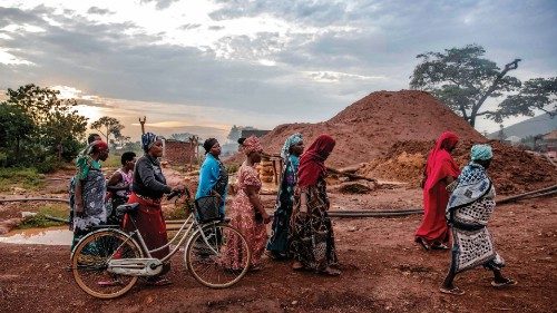 Tanzanian miners belonging to an only-women miners association walk together at sunset after their ... Tanzanian miners belonging to an only-women miners association walk together at sunset after their ...