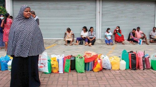 People queue up to buy kerosene oil for domestic use at a supply station in Colombo on June 7, 2022. ...