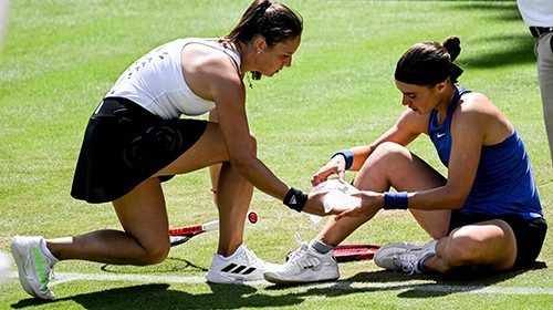 epa10010625 Daria Kasatkina (L) of Russia reacts next to to injured Ukraine's Anhelina Kalinina ...