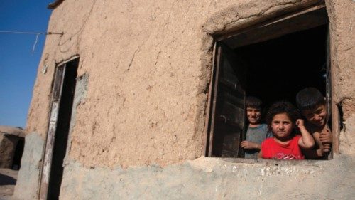 Children look out from a window of a house in Umm al-Keif village, near Tal Tamer, in northeastern ...