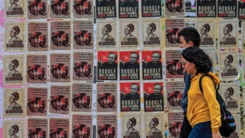 People walk past a wall with propaganda of Colombian vice-presidential candidate for the Historic ...