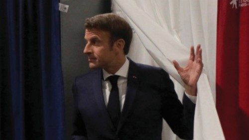 French President Emmanuel Macron walks out of a voting booth during the final round of the country's ...