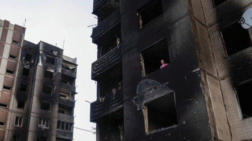 Resident Nataliia Prykhodko looks out from her burnt-out apartment in Irpin after coming back to ...