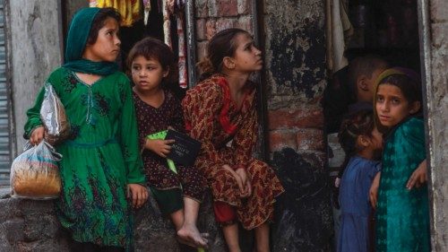 Children belonging to Afghan refugees living in Pakistan sit outside a shop on the outskirts of ...