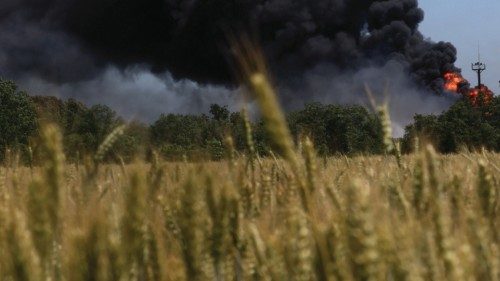 A fire from a gas processing plant continues to burn behind a field of wheat after the plant was hit ...