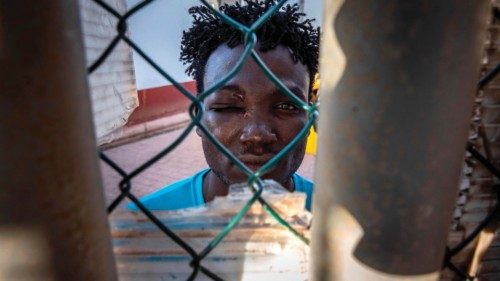 A soudanese migrant looks through a fence in a temporary centre for migrants and asylum seekers on ...