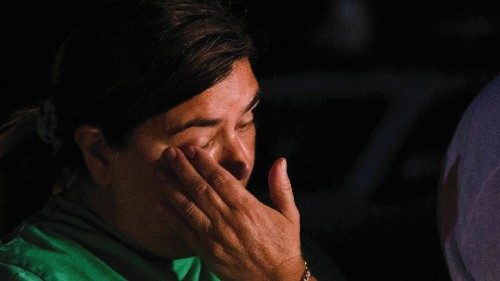 A woman reacts at the scene where people were found dead inside a trailer truck in San Antonio, ...