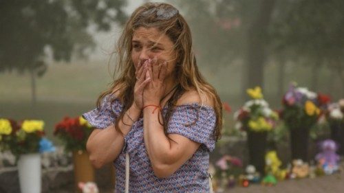 epaselect epa10039757 A woman cries near the flowers, brought to the destroyed Amstor shopping mall ... epaselect epa10039757 A woman cries near the flowers, brought to the destroyed Amstor shopping mall ...