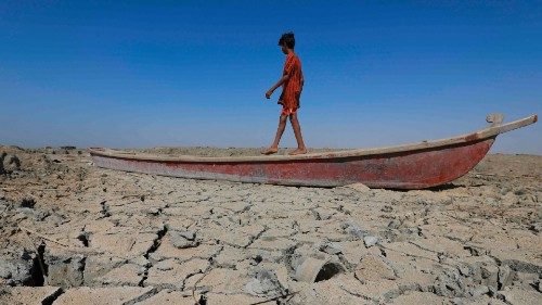 TOPSHOT - A boy walks on a boat left lying on the dried-up bed of a section of Iraq's receding ...