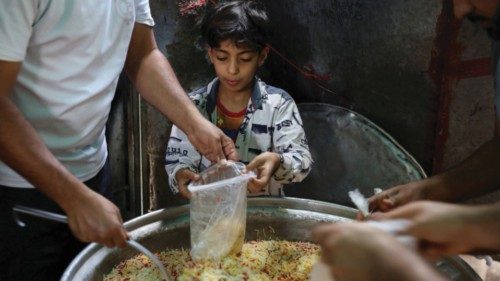 FILE PHOTO: A boy helps volunteers to prepare meals to be distributed at a charity kitchen in Sanaa, ...