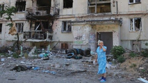 A local resident stands in front of an apartment building heavily damaged during Ukraine-Russia ...