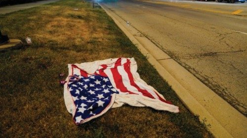An American flag blanket is seen abandoned along the parade route after a mass shooting at a Fourth ...