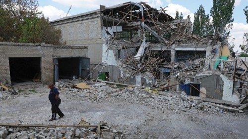 A local resident walks past a building destroyed during Ukraine-Russia conflict in the city of ...