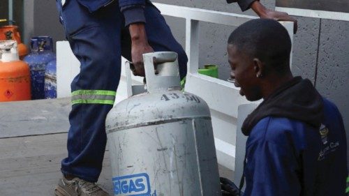Workers load liquefied petroleum gas (LPG) cylinders, as locals resort to using it as a backup ...