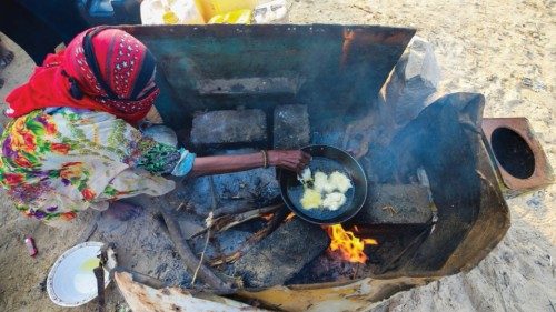 FILE PHOTO: A woman cooks a meal at a camp for displaced people in al-Ghaidha, Yemen April 11, 2022. ...