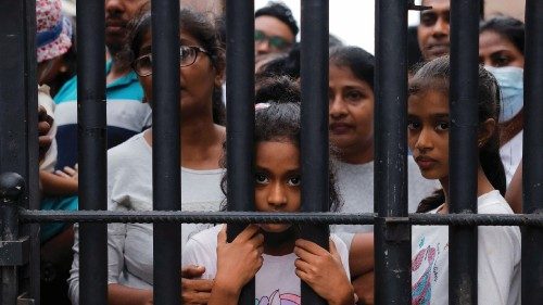 People wait behind a gate to visit the President's house on the day after demonstrators entered the ...