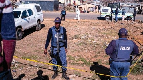 South African Police Service (SAPS) officers enforce a perimeter around a crime scene as ...