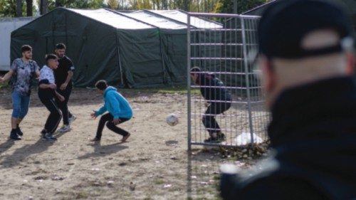 Refugees play football on the grounds of the arrival centre of the initial reception facility of the ...