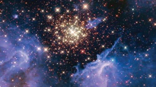 A cluster of young stars resembles an aerial burst, surrounded by clouds of interstellar gas and ...