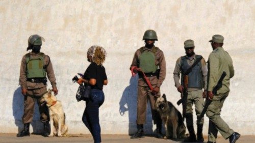 A woman walks past police officers as they stand guard, in anticipation of rumours of a national ...