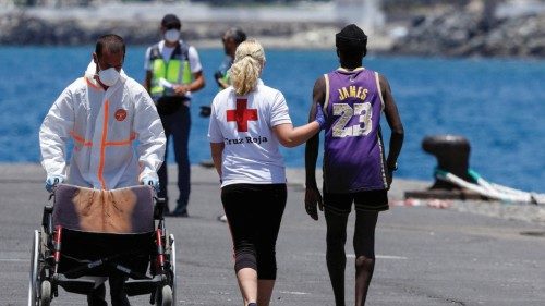 A Red Cross rescuer assists a migrant to a tent after disembarking from a Spanish coast guard ...