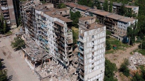 This aerial picture taken on July 13, 2022, shows destroyed buildings and residents in the yard in ... This aerial picture taken on July 13, 2022, shows destroyed buildings and residents in the yard in ...