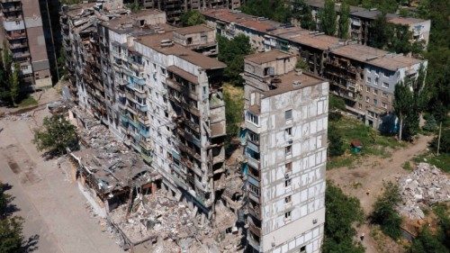 This aerial picture taken on July 13, 2022, shows destroyed buildings and residents in the yard in ...