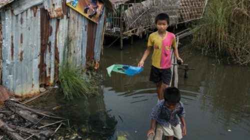 This photograph taken on September 19, 2019 shows children walking on a wooden plank over a pool of ... This photograph taken on September 19, 2019 shows children walking on a wooden plank over a pool of ...