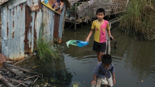 This photograph taken on September 19, 2019 shows children walking on a wooden plank over a pool of ...