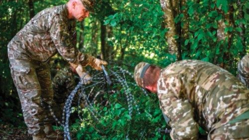 Members of the Slovenian Army disassemble a barbed wire fence at the Slovenian-Croatian border, ...