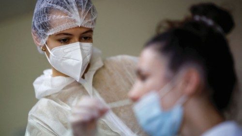 FILE PHOTO: A medical worker administers a nasal swab to a patient at a coronavirus disease ...