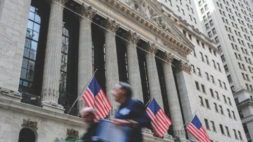 In this file photo taken on July 12, 2022, people walk past the New York Stock Exchange (NYSE) on ...