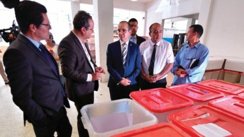 Fouad Bouasker (C), president of Tunisia's Independent Higher Authority for Elections (ISIE), checks ...