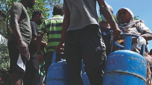 A man carries empty Liquefied Petroleum Gas (LPG) cylinders to a distribution point in Colombo on ...