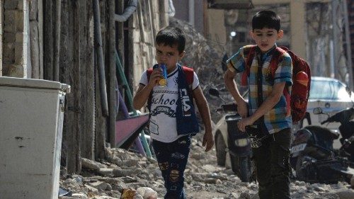 Iraqi children walk with their school bag on the shoulders on the first day of school in the ... Iraqi children walk with their school bag on the shoulders on the first day of school in the ...