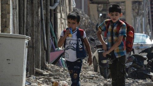 Iraqi children walk with their school bag on the shoulders on the first day of school in the ...