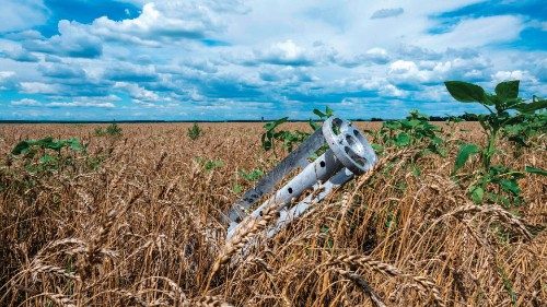 TOPSHOT - A fragment of a rocket from a multiple rocket launcher is seen embedded in the ground on a ...