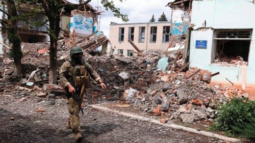 TOPSHOT - A Ukrainian serviceman passes by destroyed buildings in the Ukrainian town of Siversk, ...