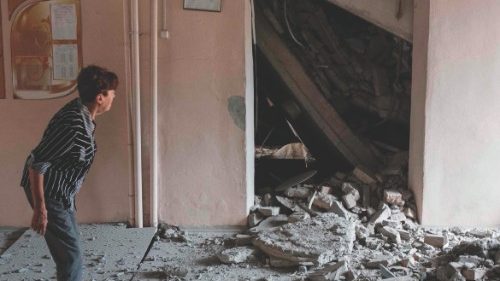 A teacher examines destructions in a school destroyed as a result of a shelling in Bakhmut, Donetsk ...