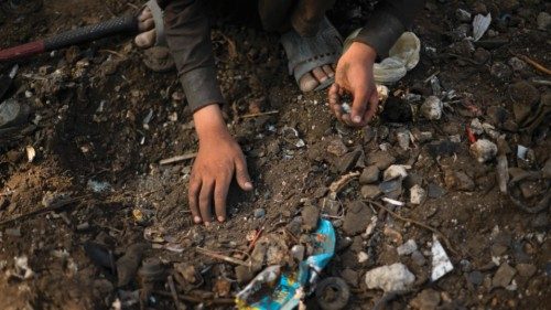 A child scavenges for scrap metal in Kabul on July 26, 2022. (Photo by Daniel LEAL / AFP)