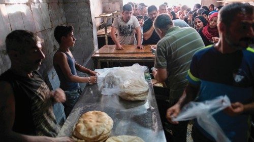 Long lines form early on July 27, 2022 outside a bakery in north Lebanon's port city of Tripoli ...