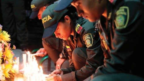 Members of Colombia's National Police light candles during a vigil in front of the police command in ...