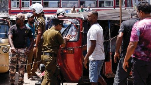 A police officer pushes back a three-wheeler which tries to break the rule to get into a Ceylon ...