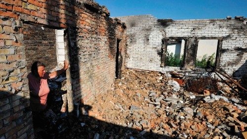 TOPSHOT - Olga, 67, looks at her house destroyed as a result of shelling in village of Moshchun, ...
