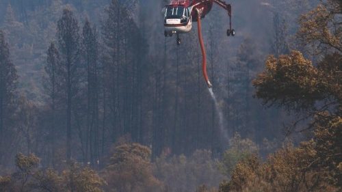 A firefighting helicopter draws water from the Klamath River to fight the McKinney Fire in the ...