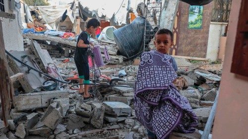 Palestinian youths salvage belongings from the rubble of their house which was destroyed during the ...