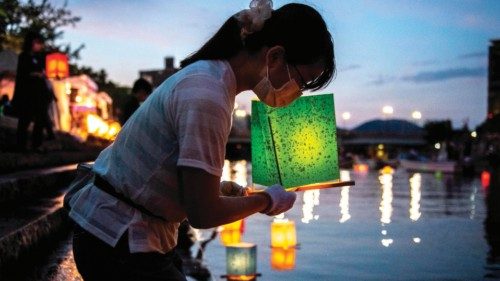 People release paper lanterns on the Motoyasu River beside the Hiroshima Prefectural Industrial ...