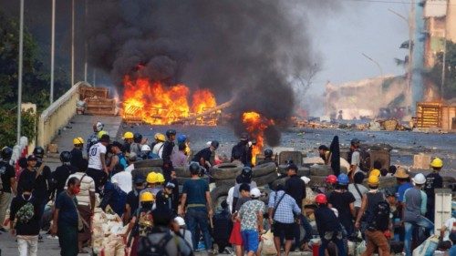 FILE PHOTO: Anti-coup protesters stand at a barricade as they clash with security forces on Bayint ...