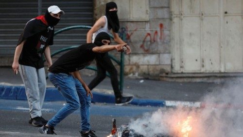 A Palestinian gestures during clashes against Israeli strikes in Gaza, in Hebron in the ...