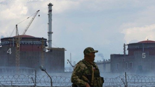 A serviceman with a Russian flag on his uniform stands guard near the Zaporizhzhia Nuclear Power ...